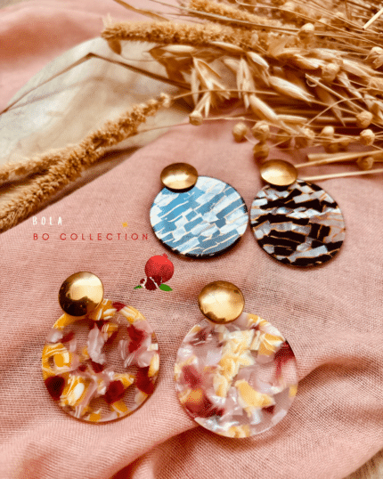 Boucle d'oreille avec pendentif de forme ronde en résine dans les coloris noir et argenté et rosé, jaune, orangé