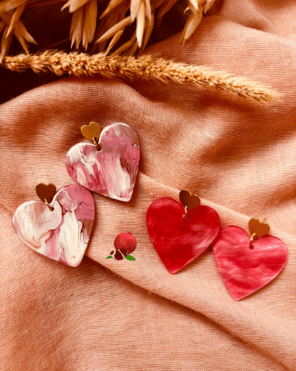 Boucle d'oreille en forme de coeur en résine. Teintes rose et rose pâle