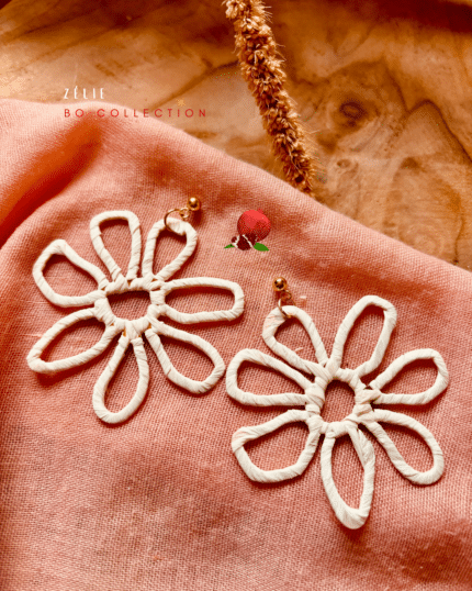 Boucles d'oreilles XXL en forme de fleur en acier inoxydable. Les fleurs sont colorées car recouvertes de raphia