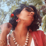 Boucle d'oreille de type créole avec anneau texturé et torsadé associé à 11 petites breloques coquillages avec des petites teintes de rouge