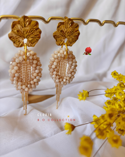 Boucle d’oreille pendante composée d'un pendentif perlé de forme ovale et d’une pampille 2 coloris au choix : nude ou écru marbré Clou d’oreille en acier inoxydable Longueur totale : 8,5 cm