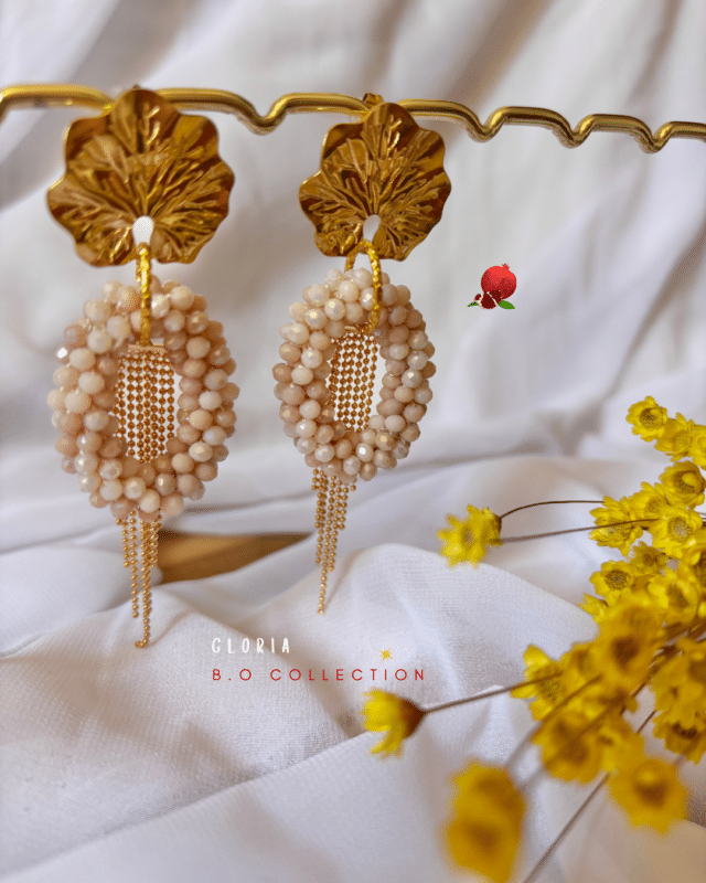 Boucle d’oreille pendante composée d'un pendentif perlé de forme ovale et d’une pampille 2 coloris au choix : nude ou écru marbré Clou d’oreille en acier inoxydable Longueur totale : 8,5 cm