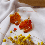 Boucle d'oreilles avec fleur en résine coloris orange marbré Diamètre fleur : 4 cm Créole en plaqué or