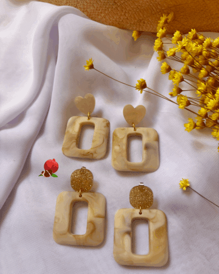 Boucle d'oreille avec pendentif évidé en forme carré (coloris beige marbré) 2 finitions possibles : Clou d'oreille en forme de carré doré pailleté ou en forme de coeur