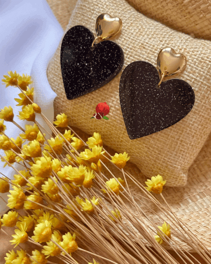 Boucle d'oreille en forme de coeur en résine. Noir pailleté