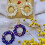 Clou d’oreille en plaqué or Pendentif tissé avec perles en crystal de verre 2 coloris disponibles : blanc, bleuté/violet Longueur : 5 cm