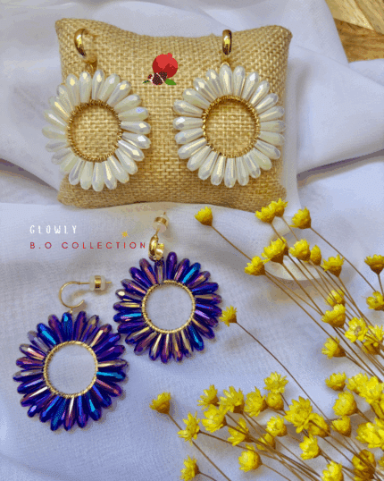 Clou d’oreille en plaqué or Pendentif tissé avec perles en crystal de verre 2 coloris disponibles : blanc, bleuté/violet Longueur : 5 cm