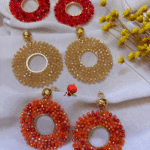 Clou d’oreille en plaqué or Pendentif tissé à la main avec perles en crystal de verre (diamètre 5 cm) 3 coloris disponibles : ambre, orange, rose/rosse fuschia Longueur : 6 cm