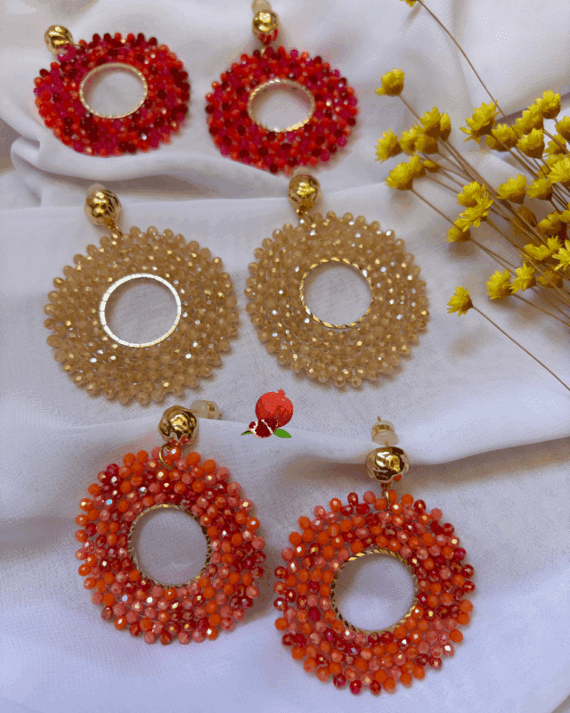 Clou d’oreille en plaqué or Pendentif tissé à la main avec perles en crystal de verre (diamètre 5 cm) 3 coloris disponibles : ambre, orange, rose/rosse fuschia Longueur : 6 cm
