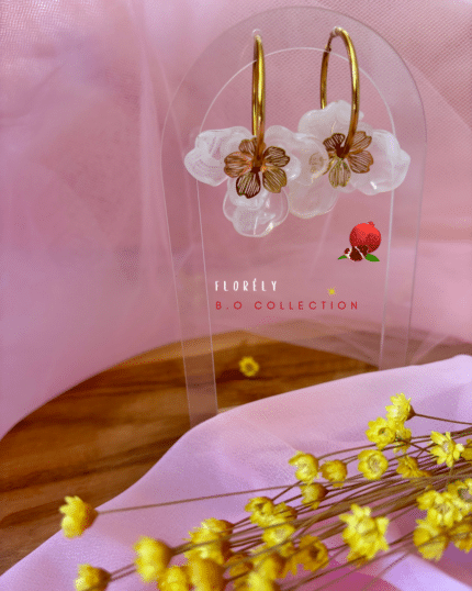 Créole en acier inoxydable 3 pendentifs fleurs  : 2 en résine (coloris blanc) et 1 dorée en acier inoxydable