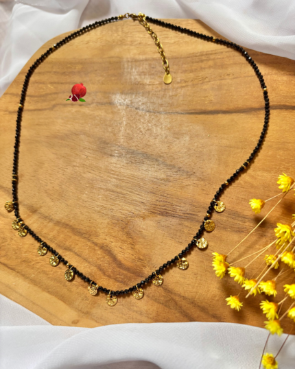 Collier à pampilles dorées et perles de verre à facettes  Coloris noir Longeur du collier : 55 cm