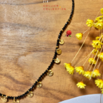 Collier à pampilles dorées et perles de verre à facettes  Coloris noir Longeur du collier : 55 cm